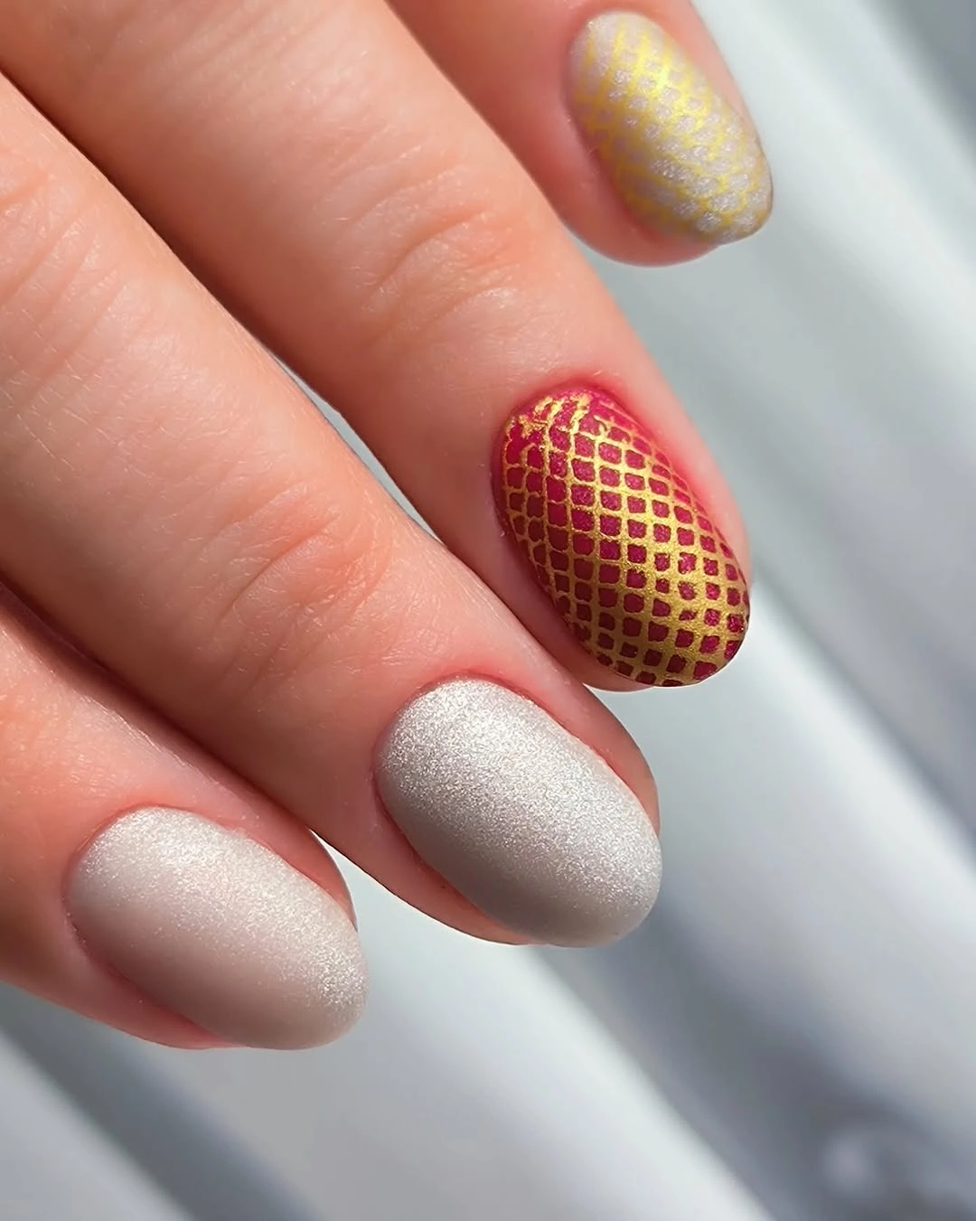 Soft silver gray nails with red and gold lattice accent