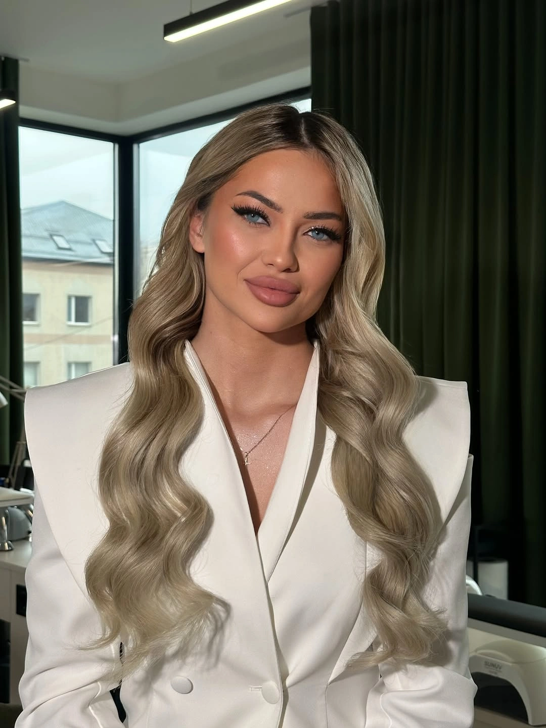 Long blonde center-parted hair with balanced soft S waves