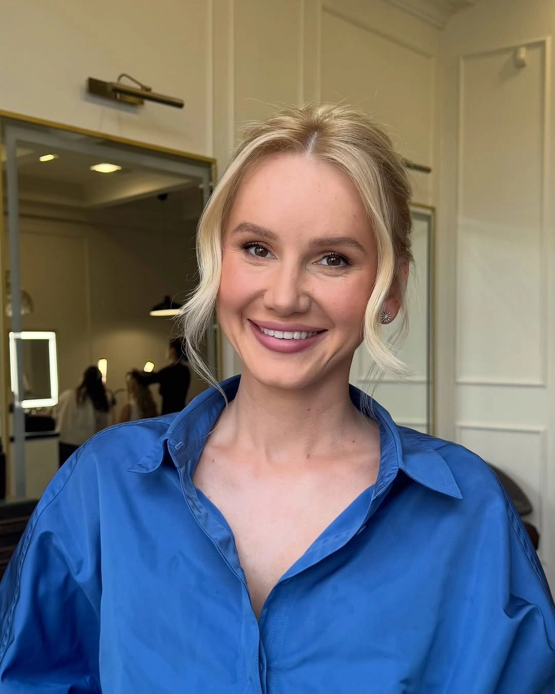 Blonde center-parted hair gathered back with loose front strands