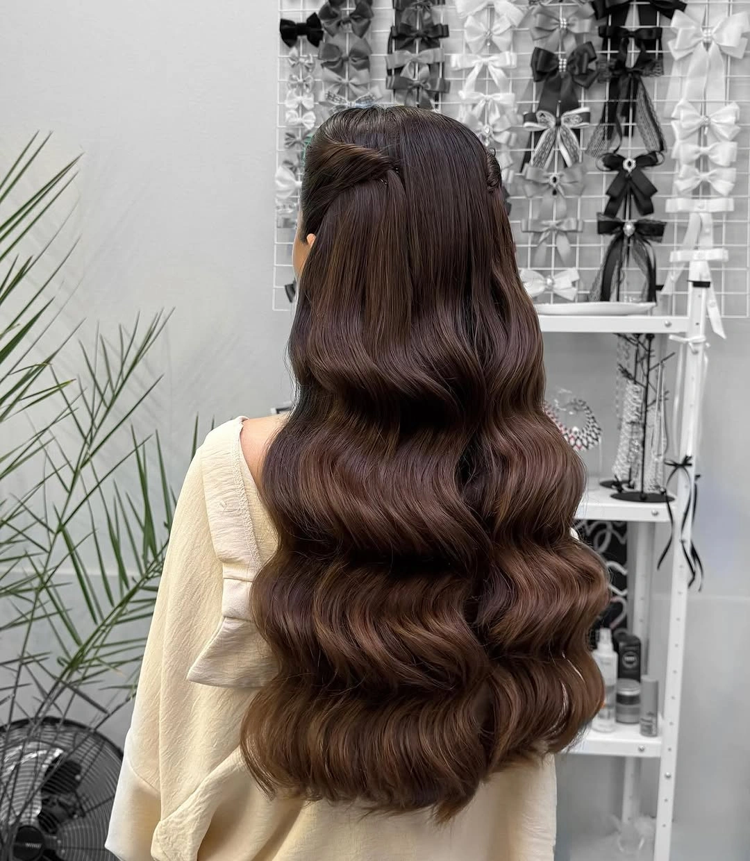 Long brown center-parted half-up hair with broad waves