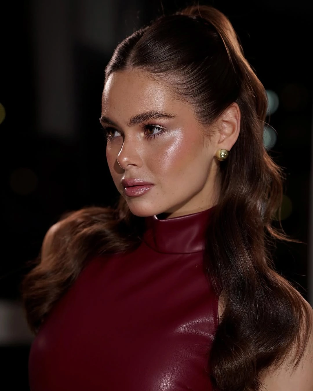 Smooth center-parted high ponytail with wavy lengths