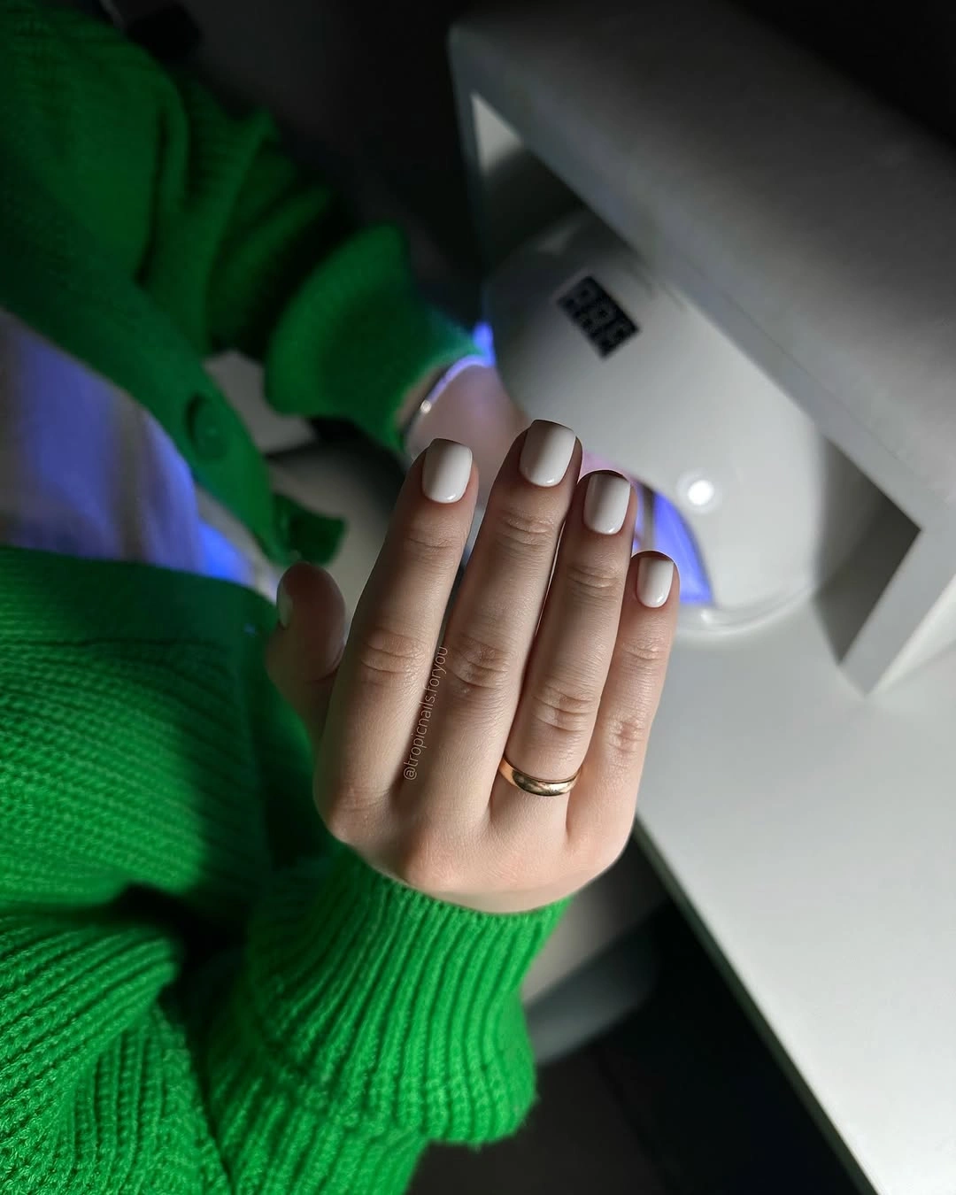 Medium square nude nails with pale tips and tiny dark accents