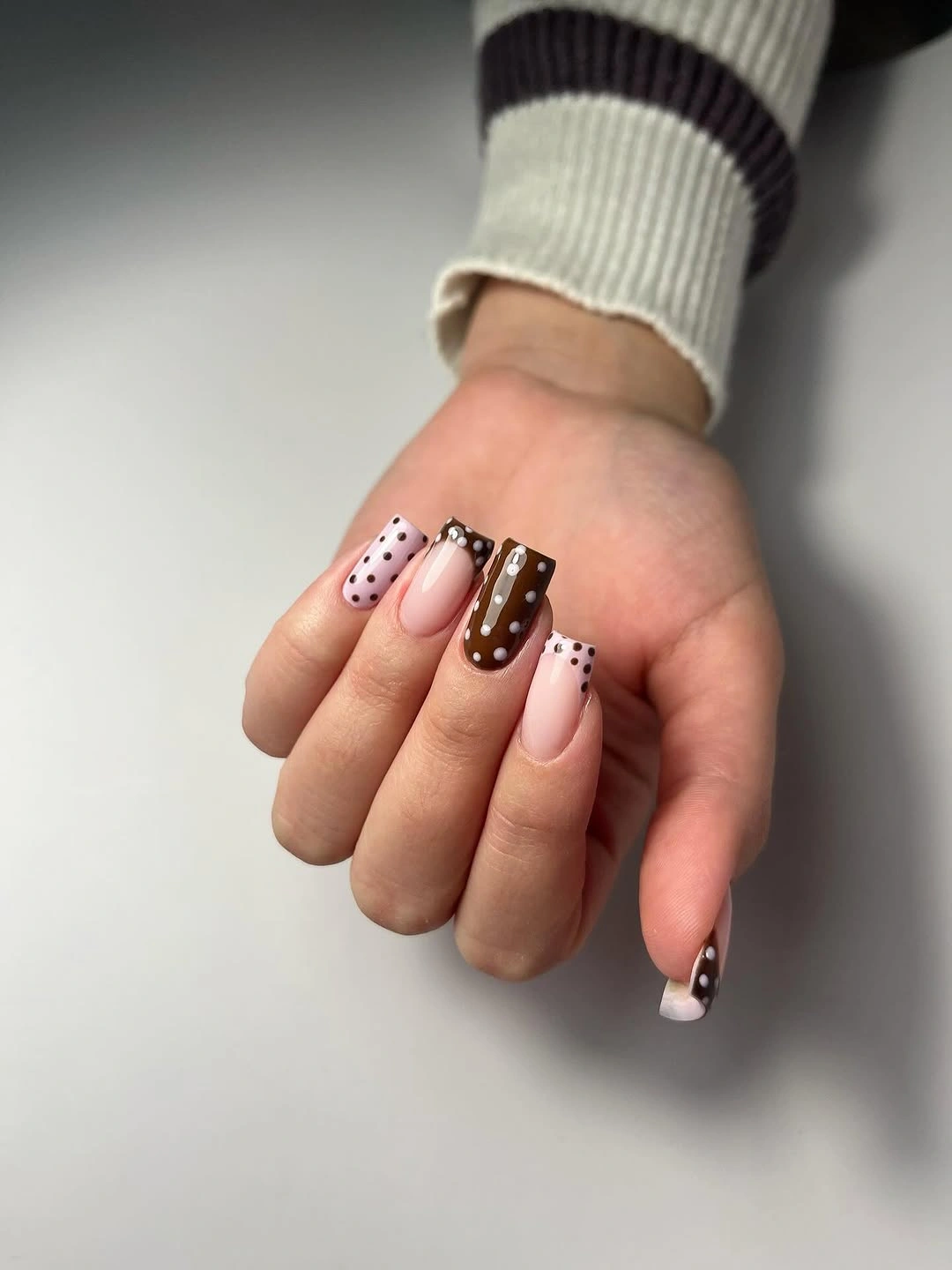Short square nails with nude brown panels and dotted details