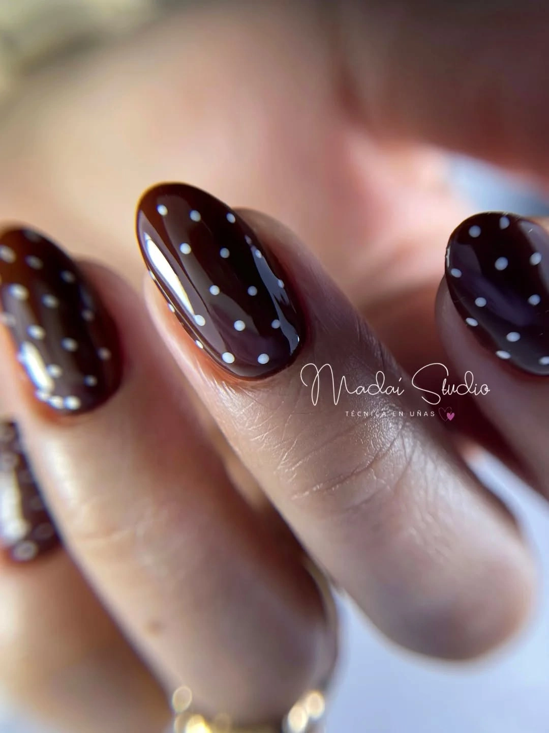 Short dark chocolate oval nails with muted blue dots