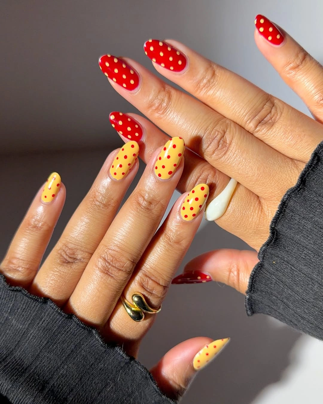Red and yellow nails with small contrasting white dot details