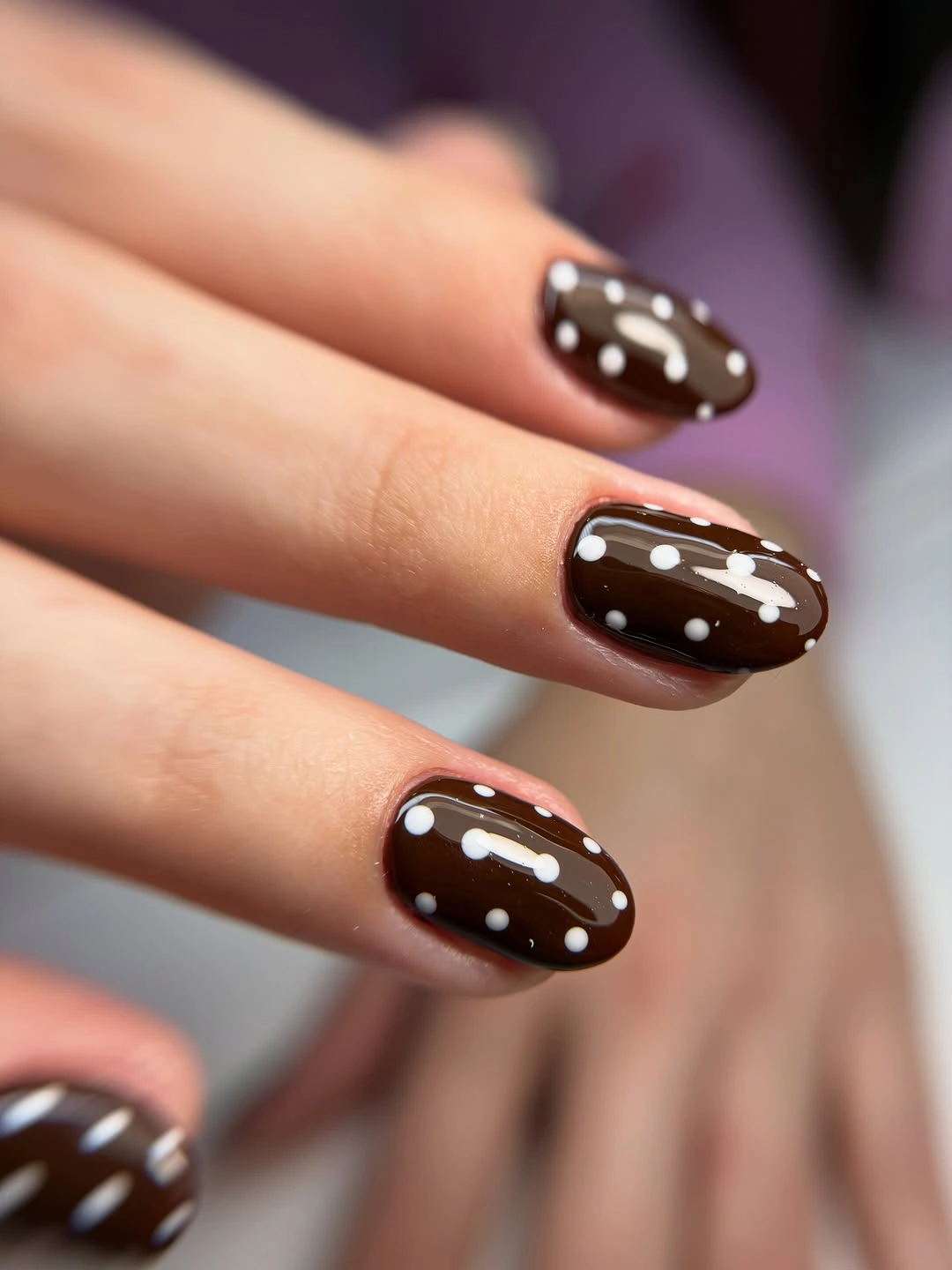Short dark chocolate nails with small white polka dots