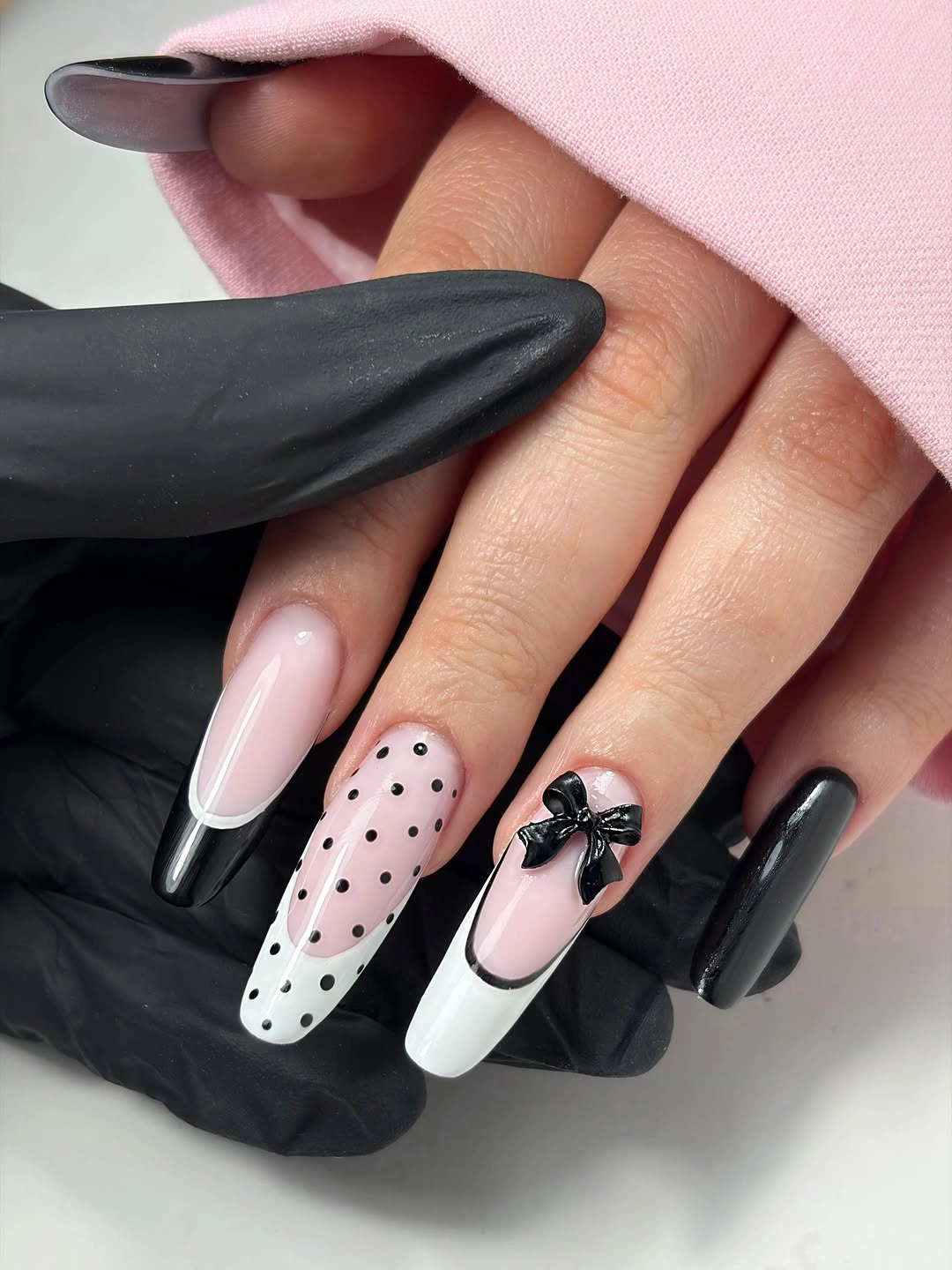Long pink black and white nails with dots and bow accent