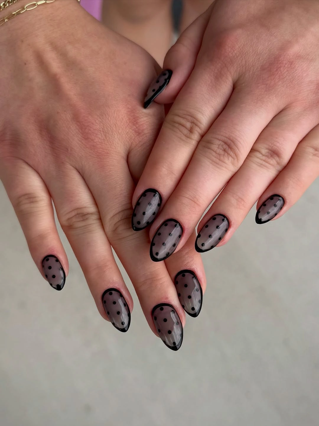 Long pointed nails with sheer dark sections black dots and edges