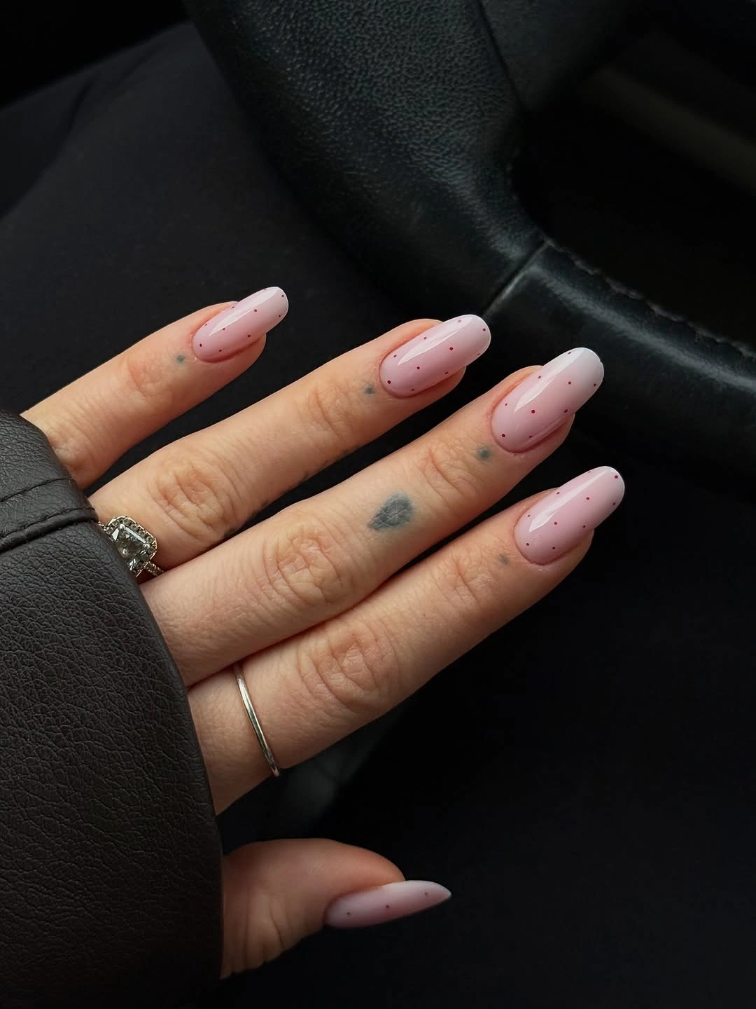 Medium blush almond nails with sparse small black dots