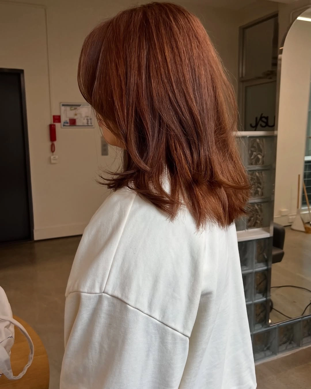 Medium copper auburn hair with soft waves and layered ends