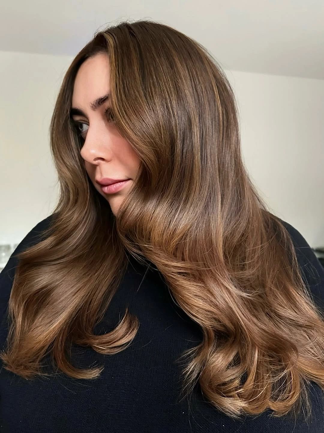 Long chestnut brown hair with center part and face framing waves