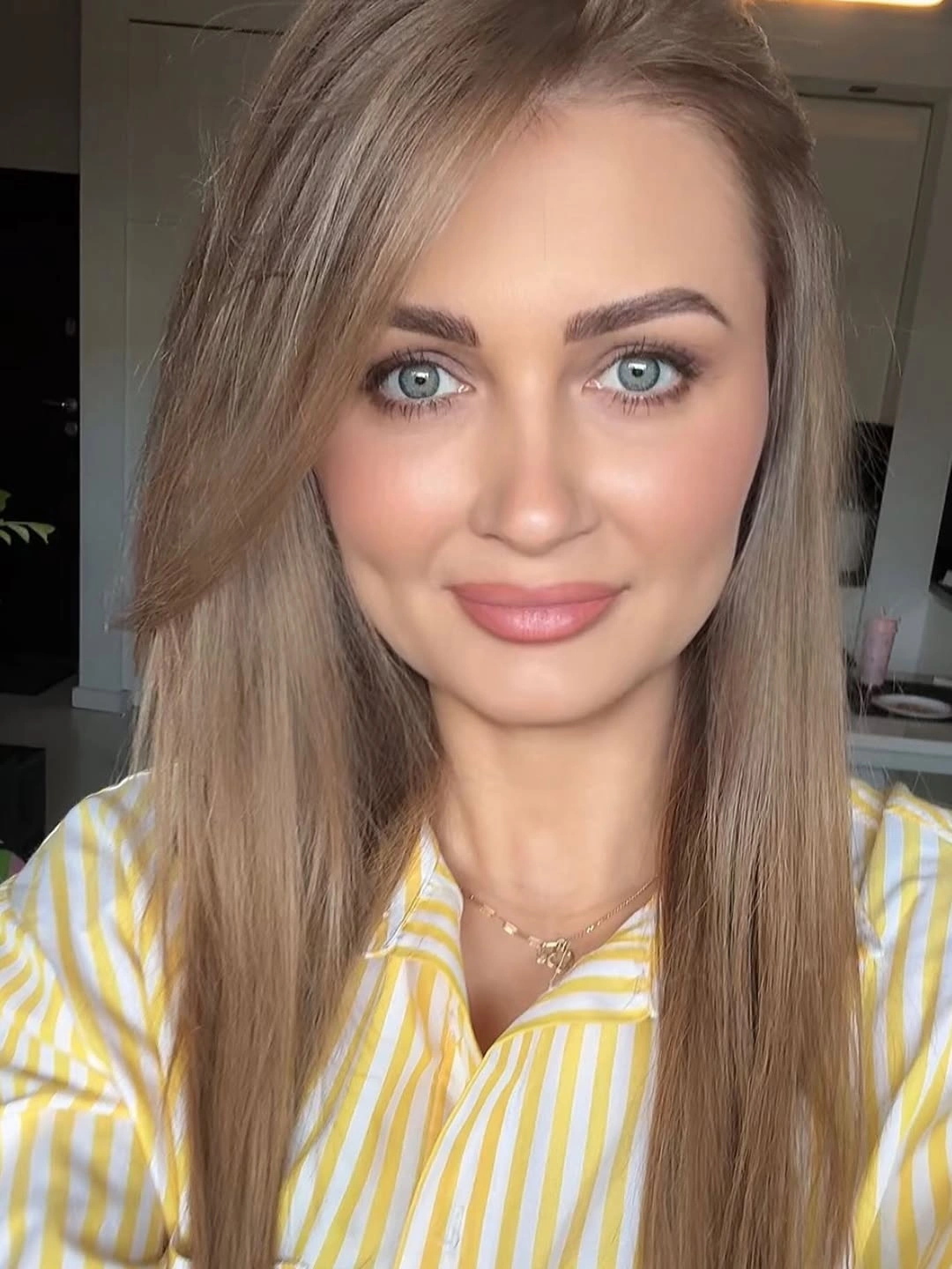 Long cool ash blonde hair with deep side part and smooth finish