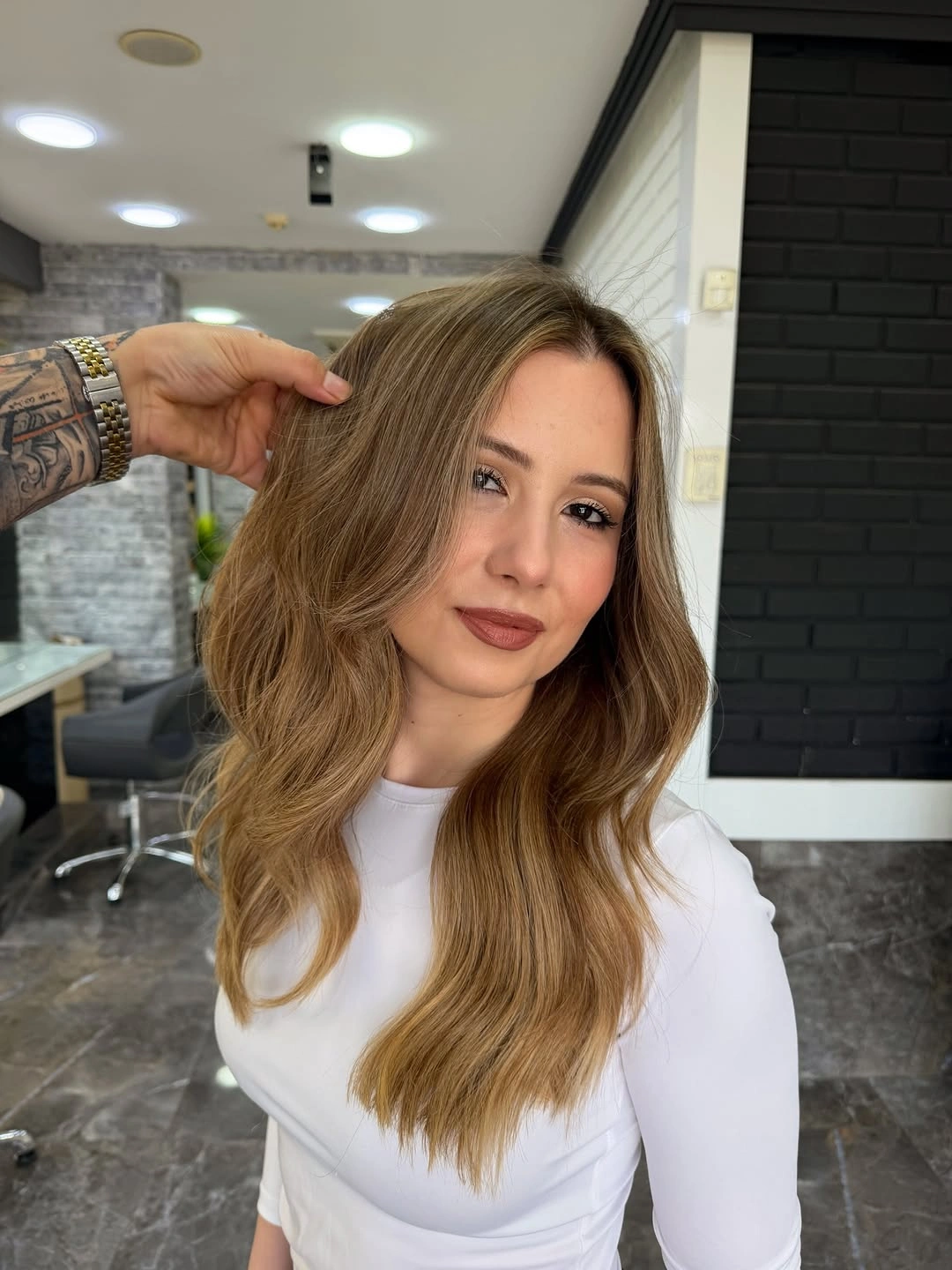 Long honey brown hair with side part and loose waves