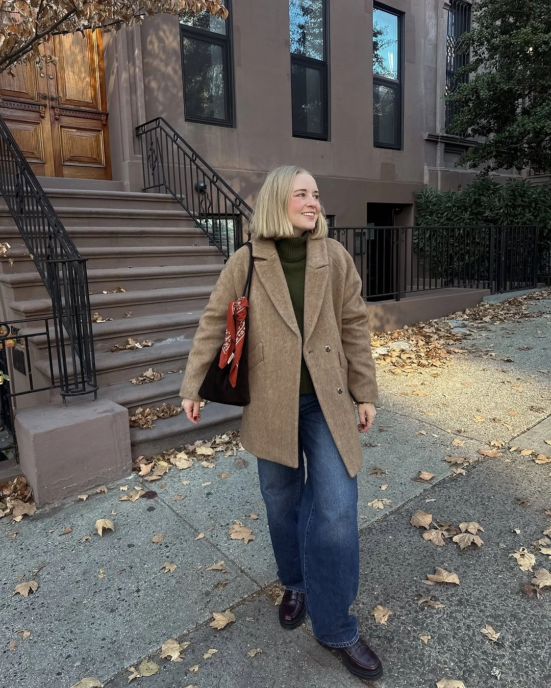 Camel coat with olive knit, blue jeans and warm shoulder bag
