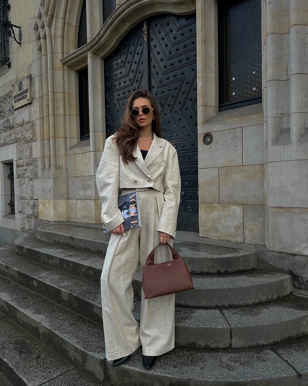 Cream tailored suit with dark top and structured brown handbag
