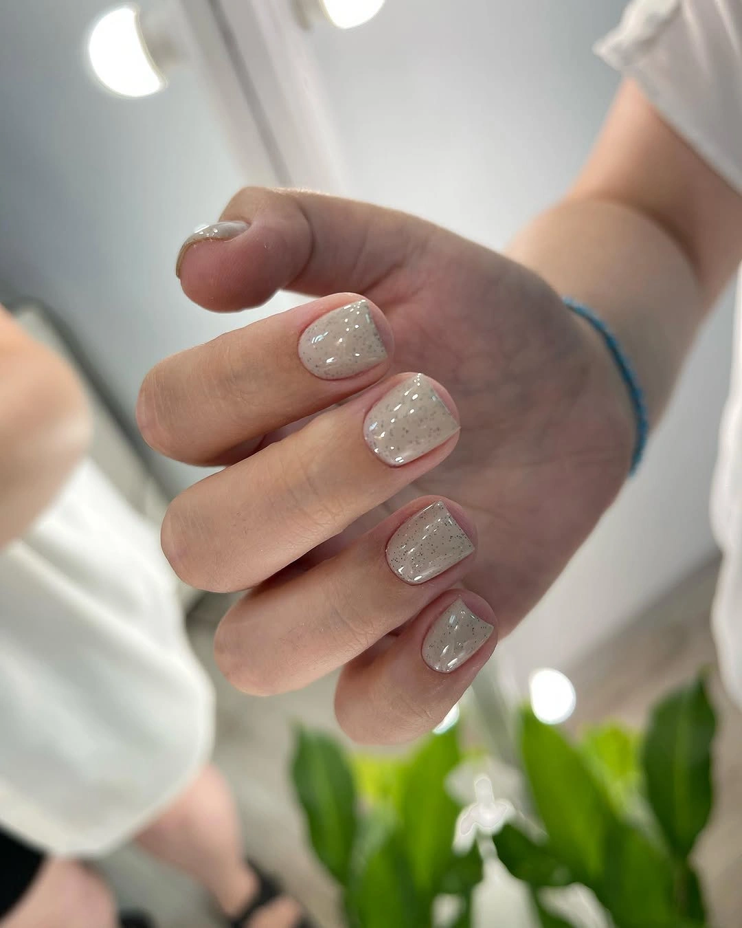 Short rounded square milky nails with pearl sheen and tiny dots