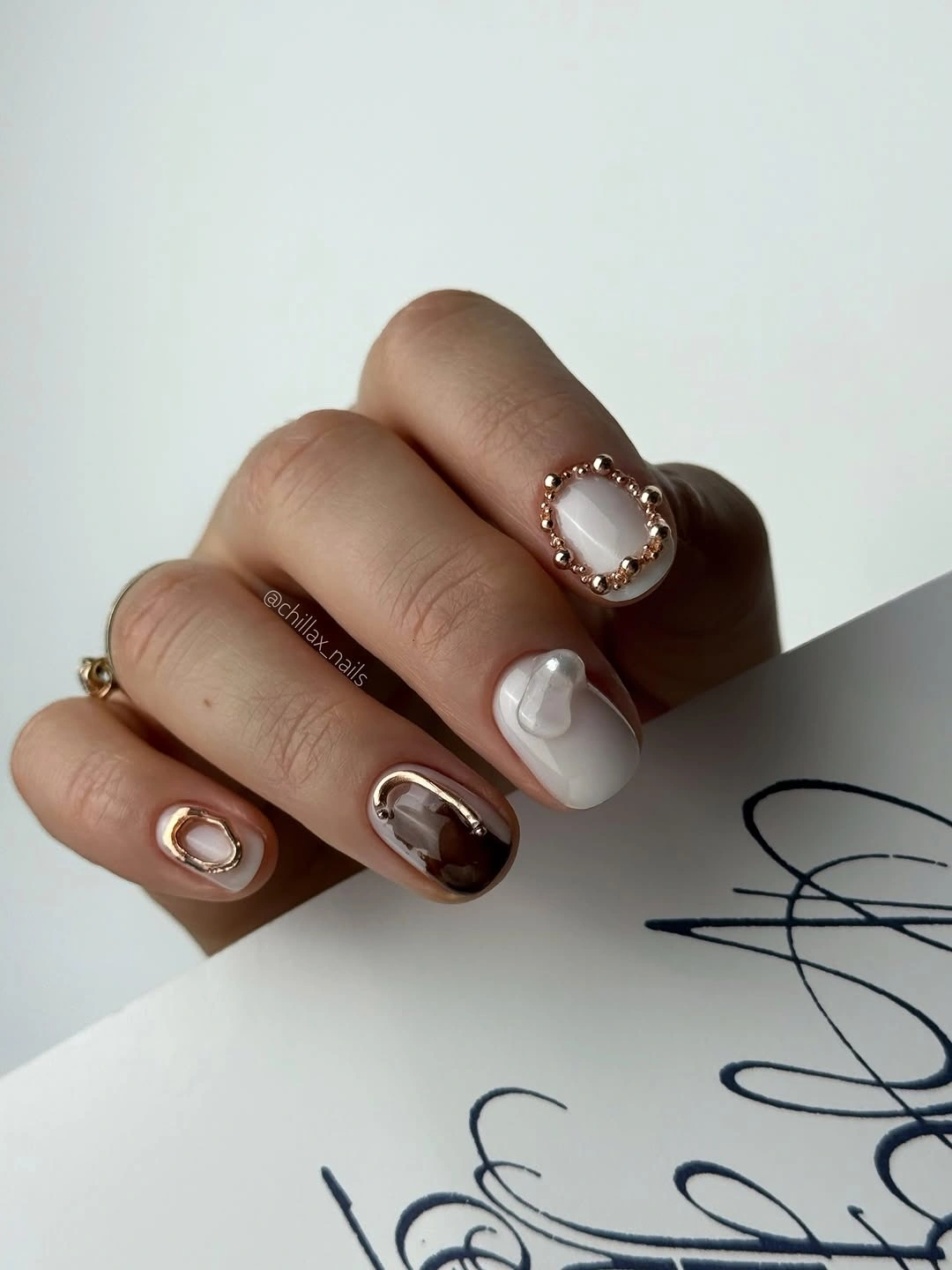 Short squoval nails mixing chocolate brown and milky white accents