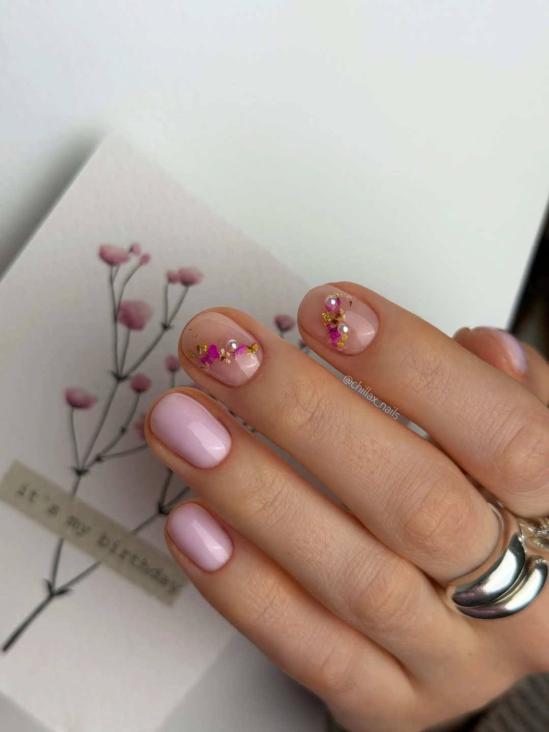Short rounded square pink nails with tiny colorful accent details