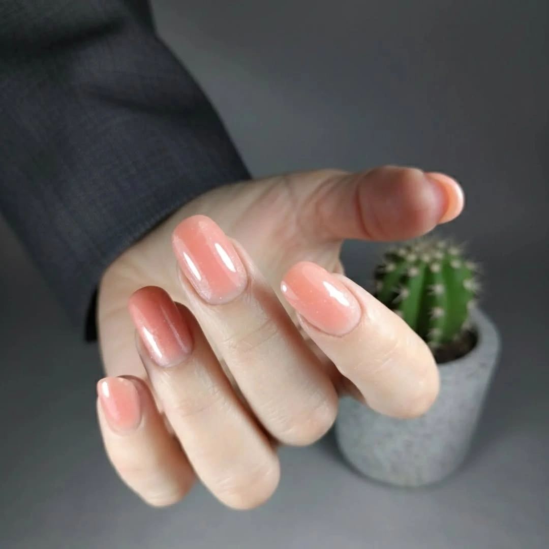 Short rounded square nails in a glossy peach coral color