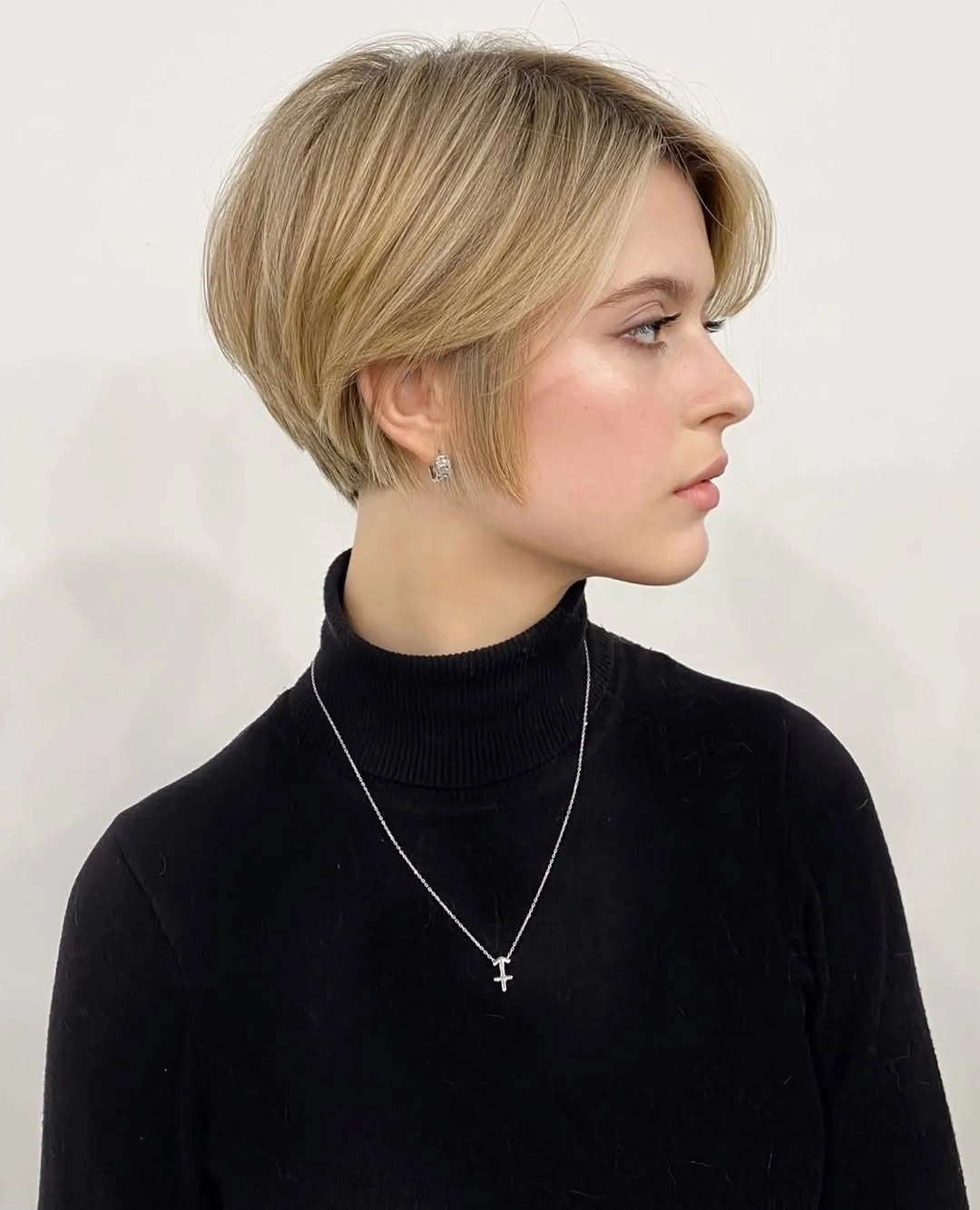 Short blonde stacked bob with side-swept front