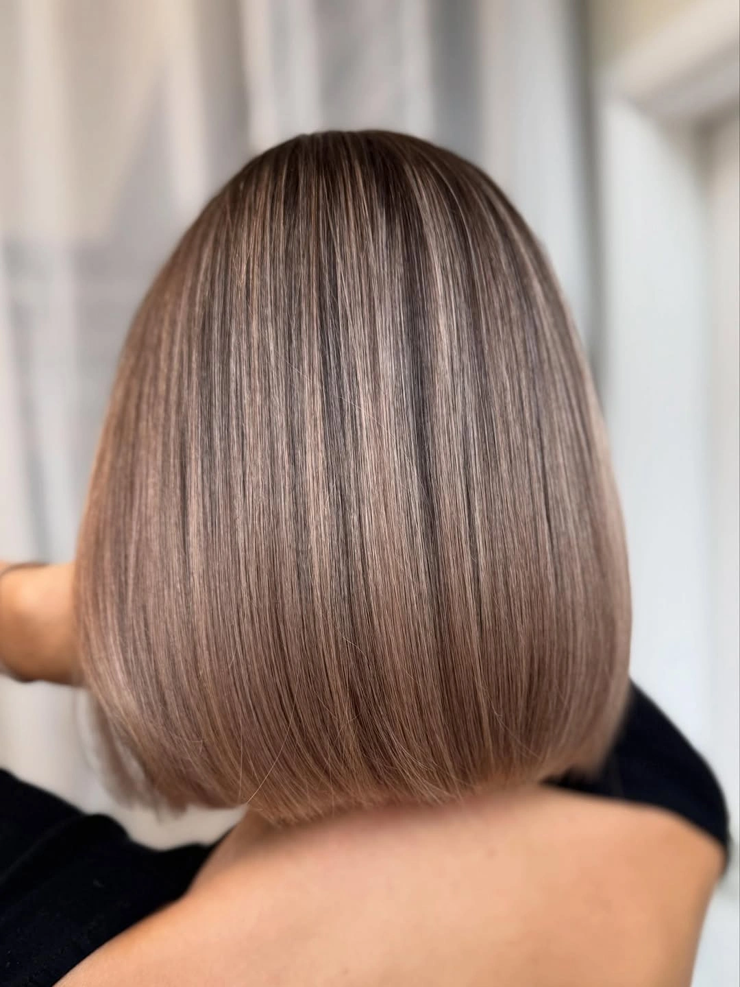 Rear view of taupe blonde bob with blunt edge
