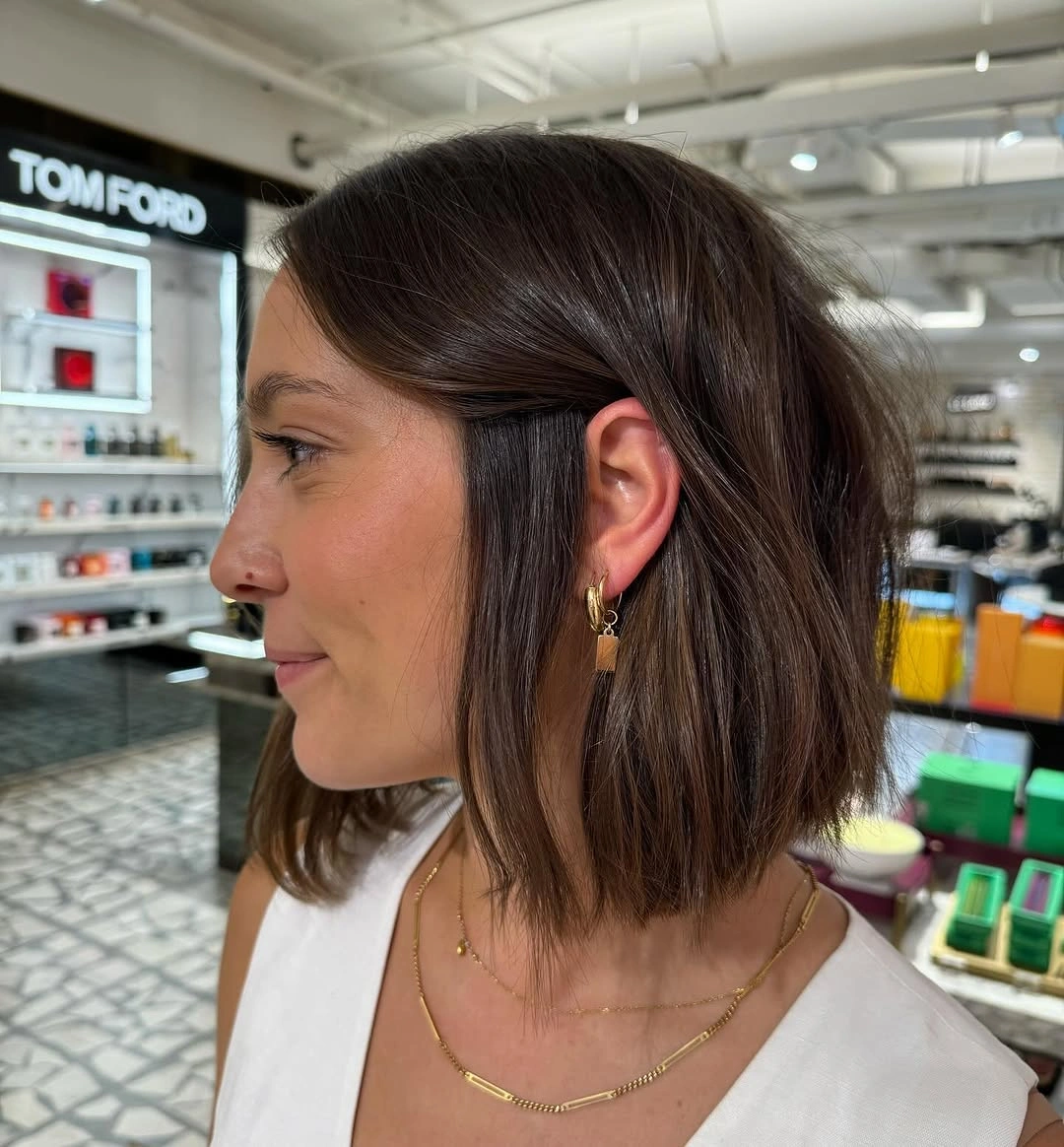 Brunette side-profile bob tucked behind one ear