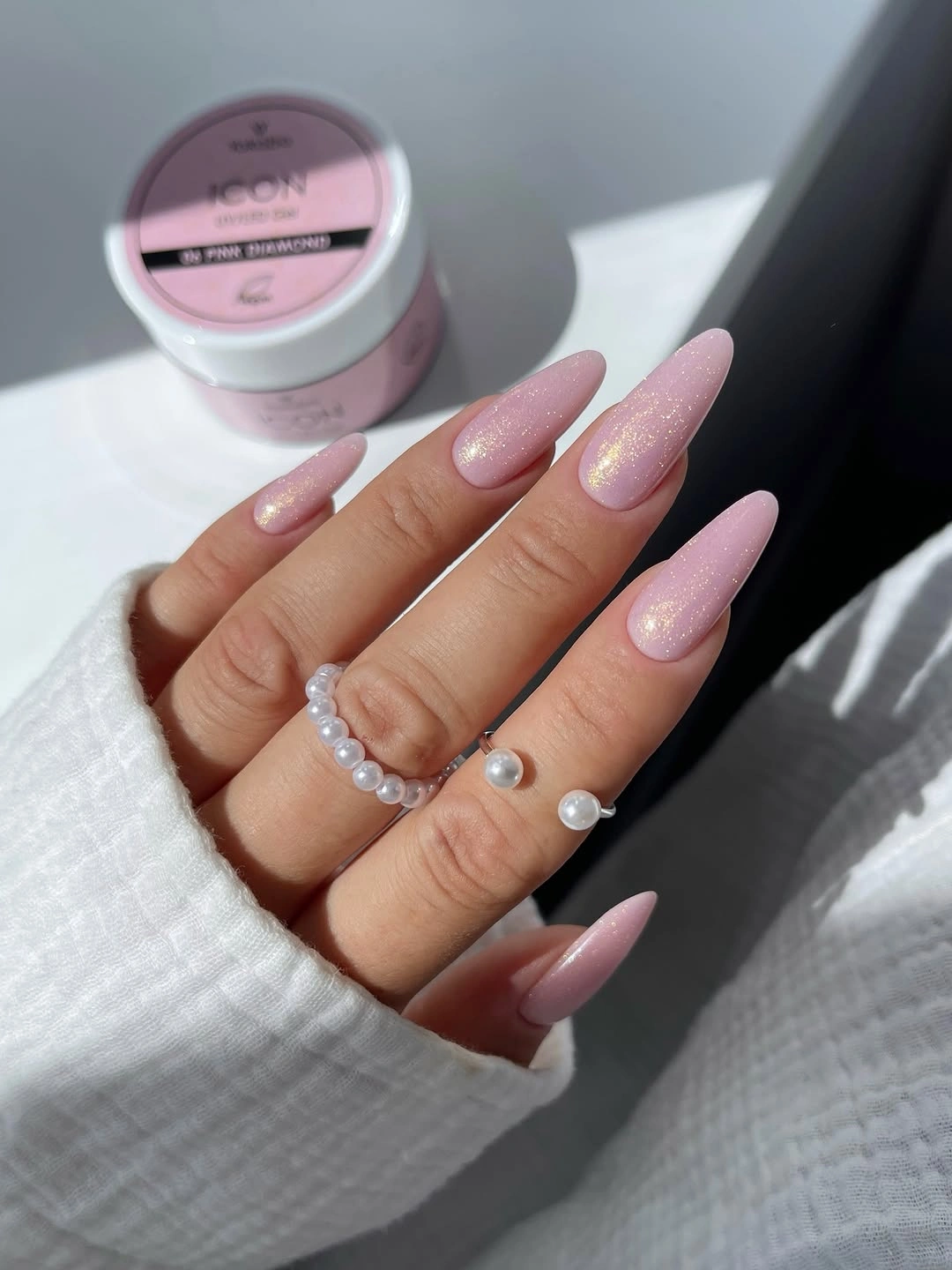 Long almond nails with uniform soft pink shimmer and glossy finish