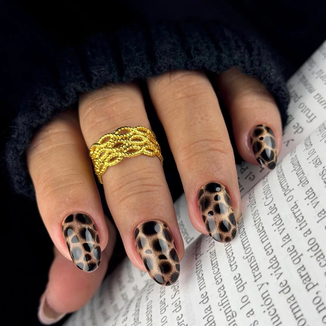 Short almond nails with nude base and black-brown leopard-like spots