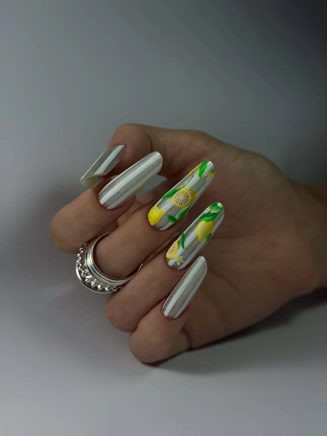 Long almond nails with cream-white lines and citrus-like yellow green accents