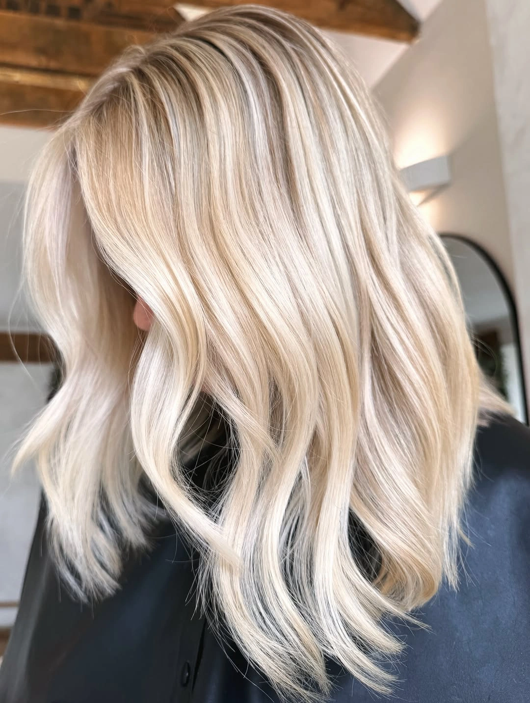 Mid-length pale blonde waves with soft beige root depth