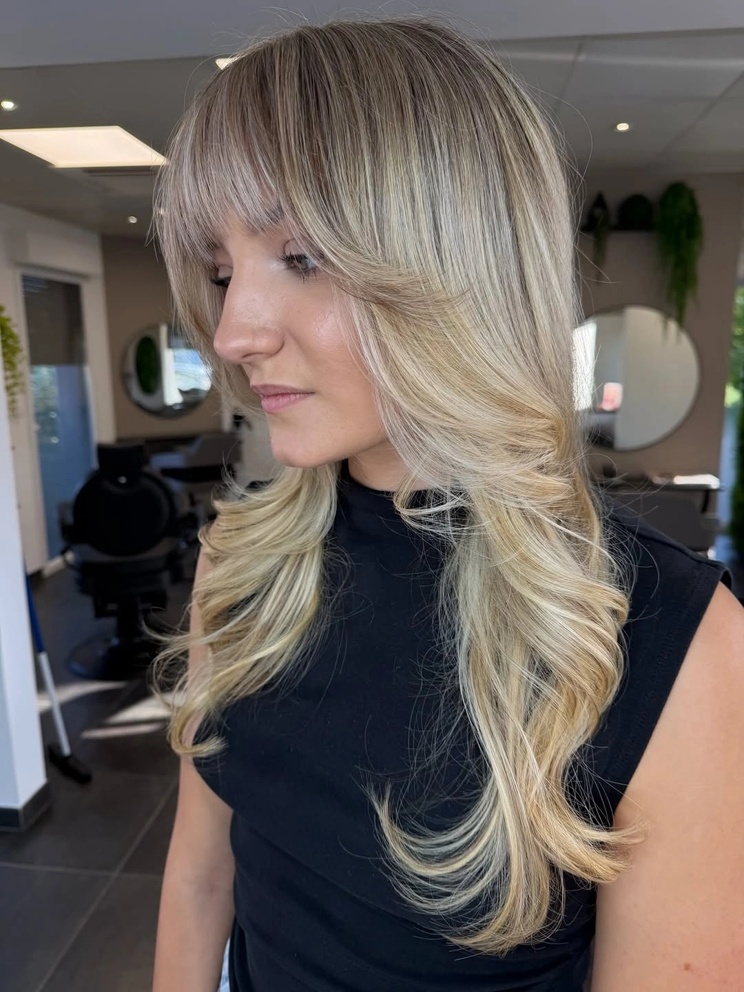Long layered blonde hair with fringe and curled ends