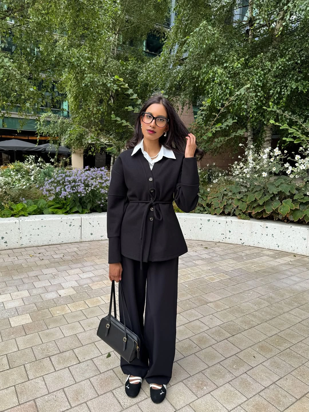 Black waist-tied layer over white collar and wide trousers