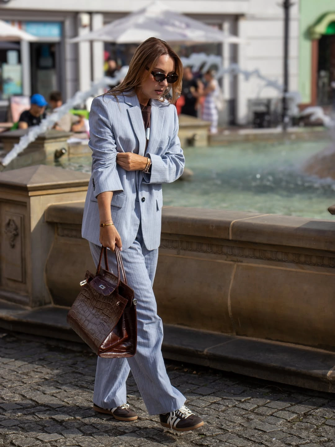 Pale blue oversized jacket and trousers with dark sneakers