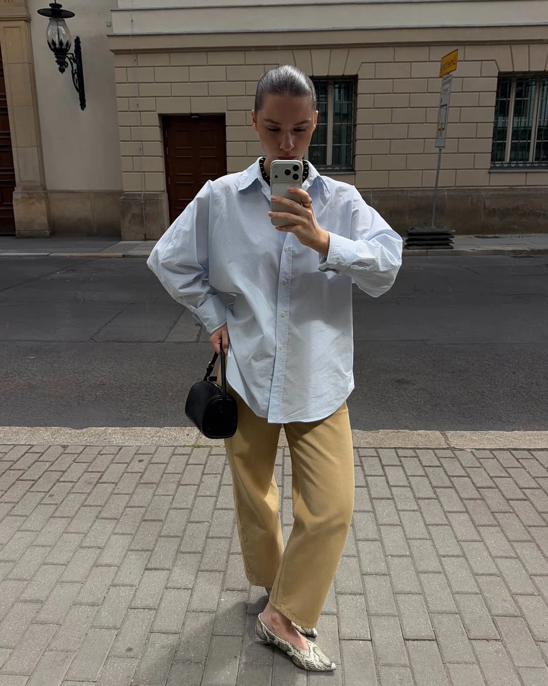 Pale blue untucked shirt with tan trousers and patterned flats