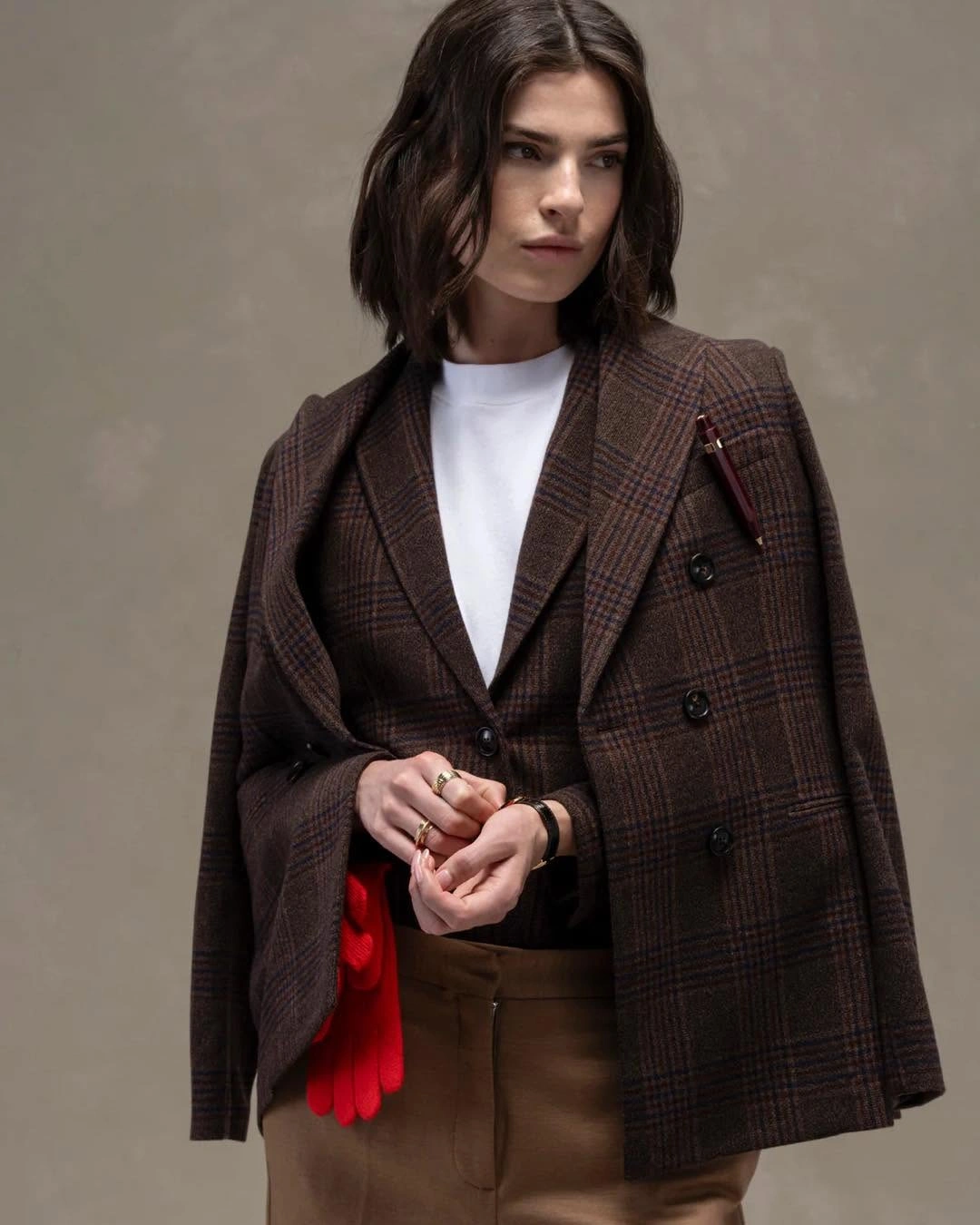 Brown checked layer over white top with red accessory