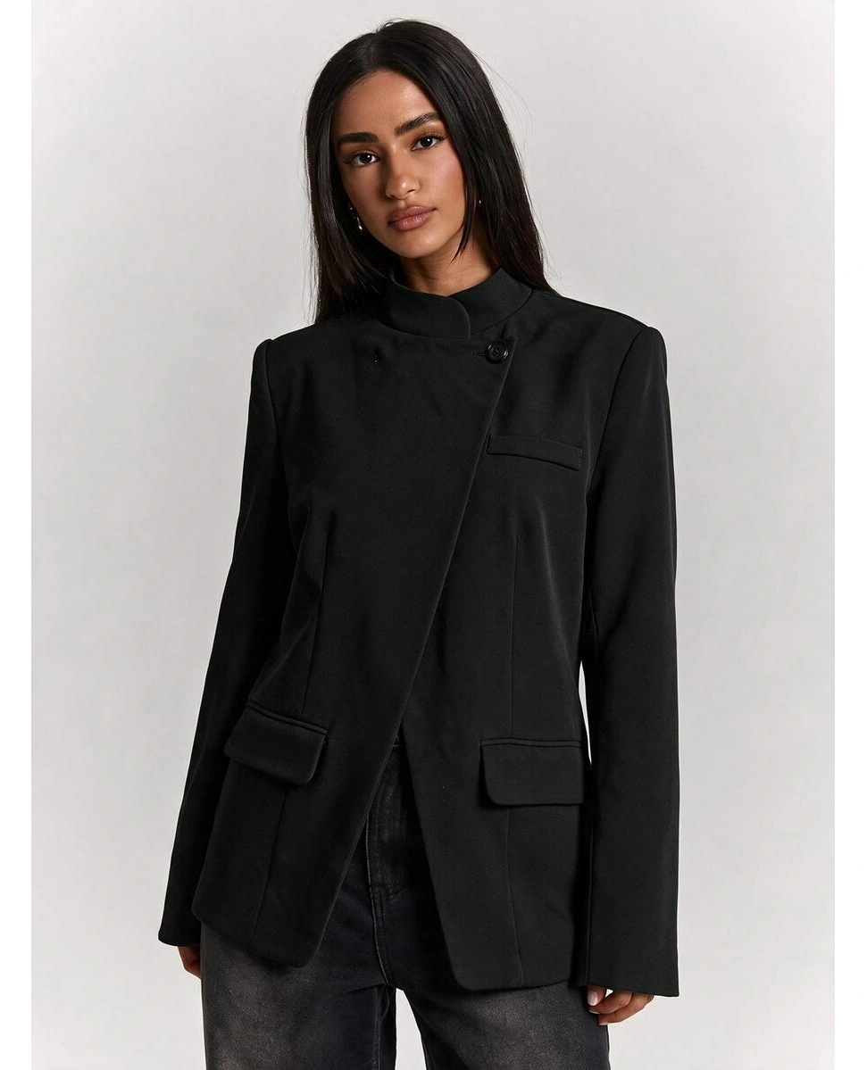 Black structured jacket with off-center front and dark pants