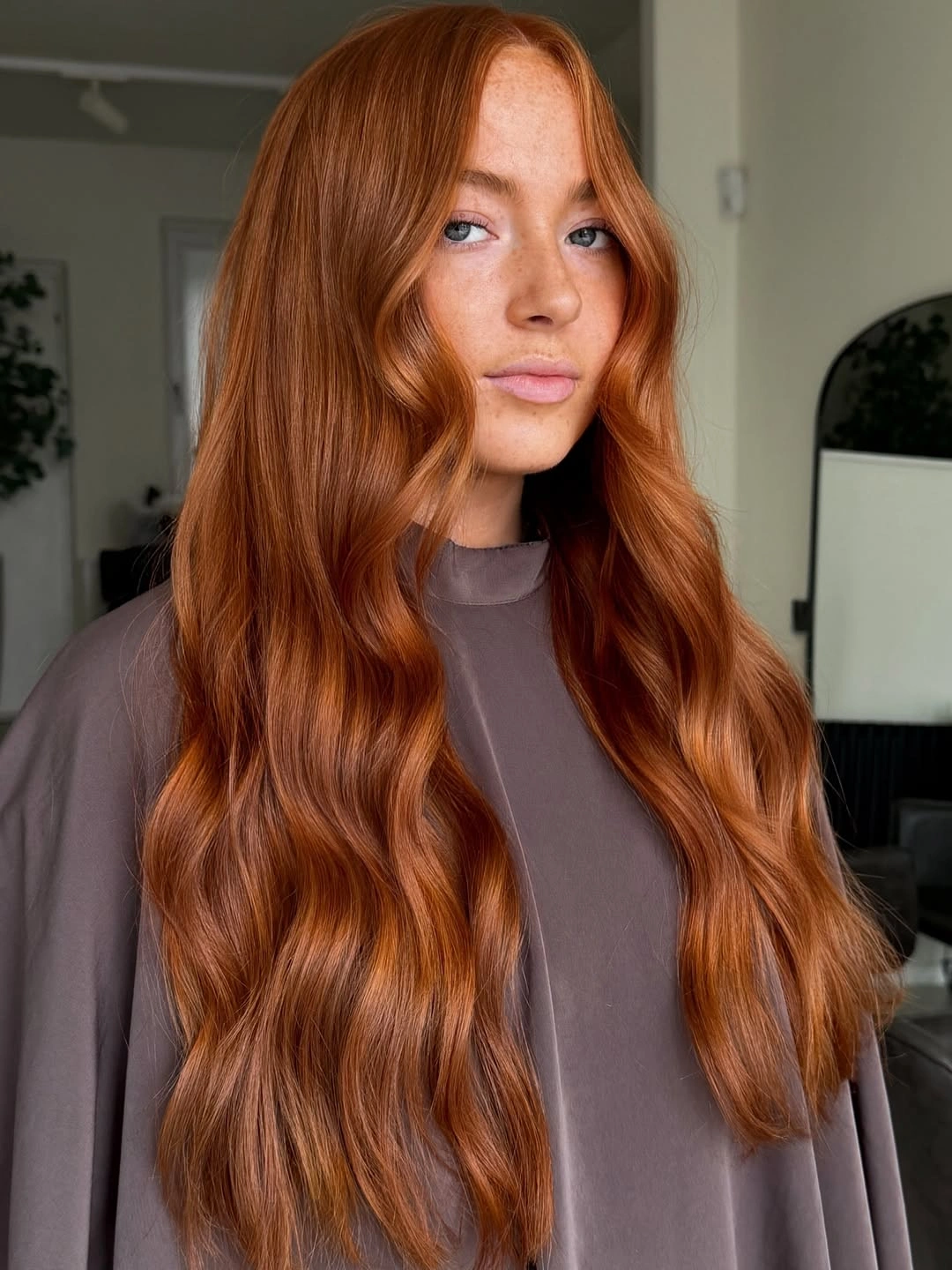 Very long copper-red hair with broad waves and near-center part