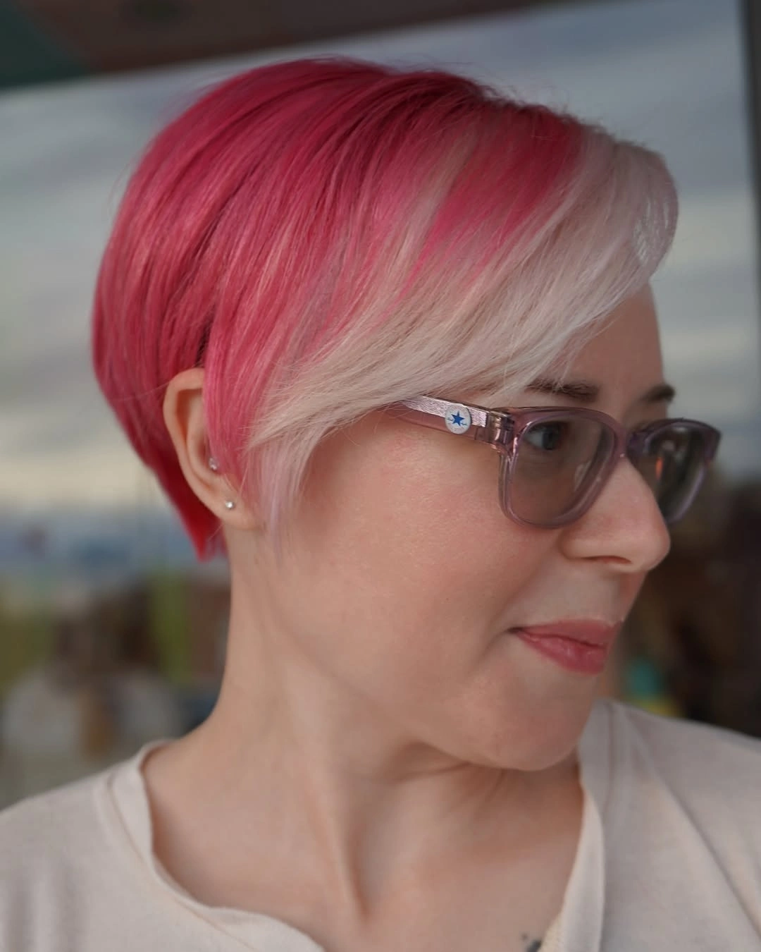 Short pink hair with pale side-swept bangs and close-cut side