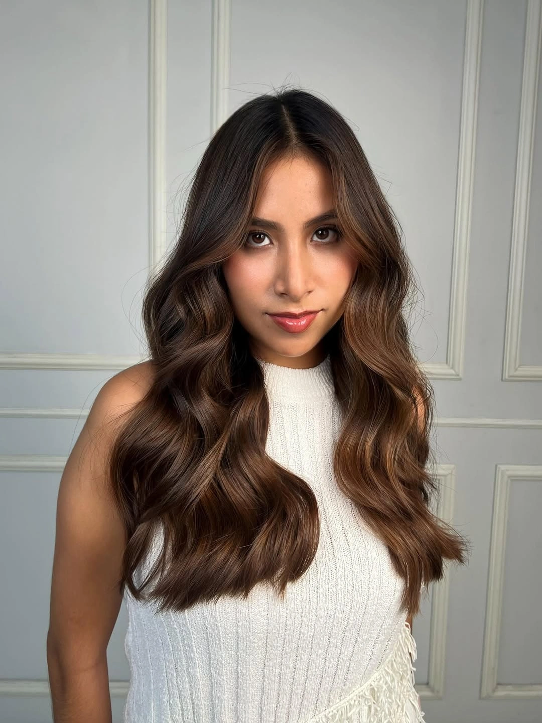Long deep-brown hair with center part and large symmetrical waves