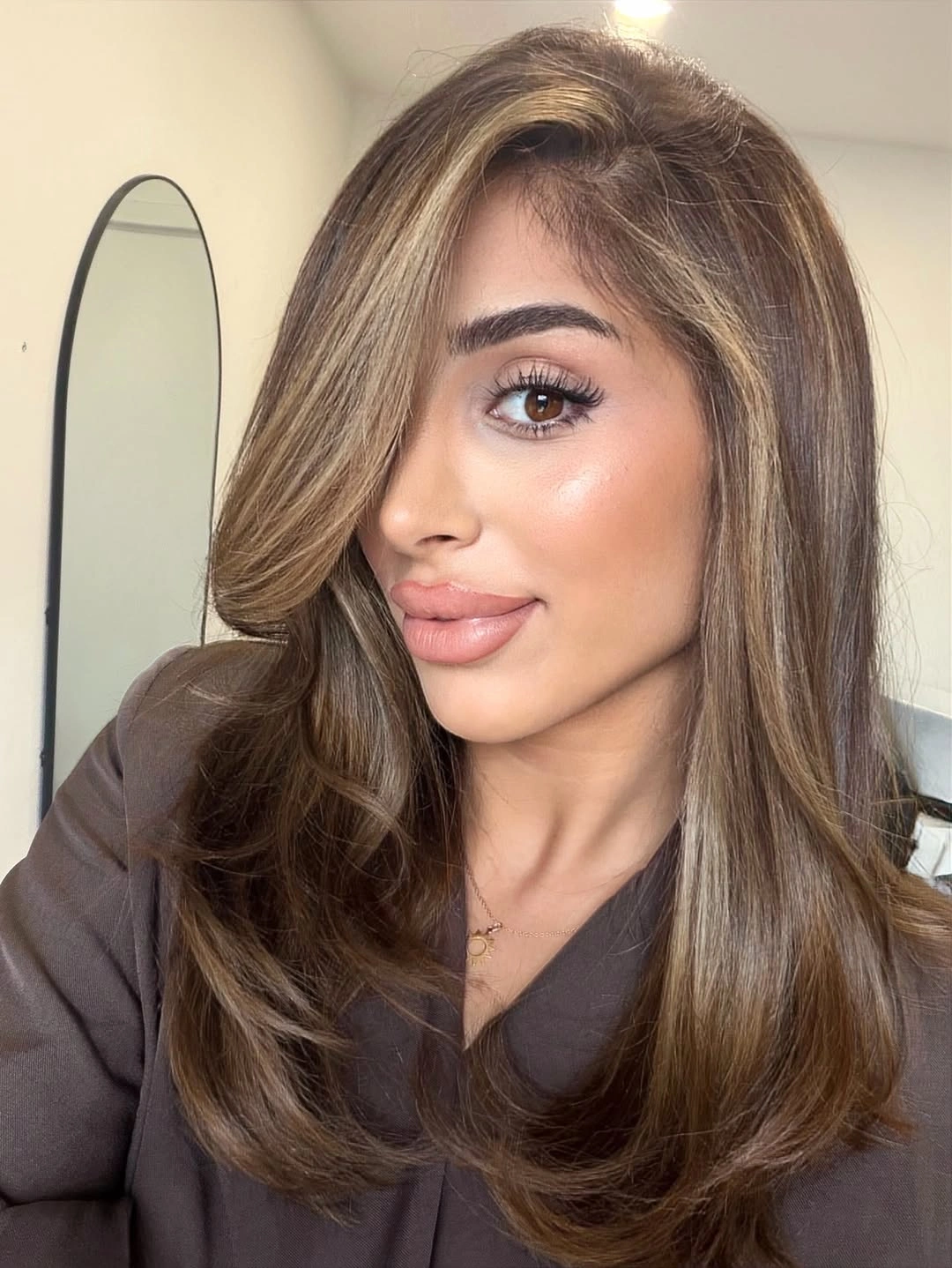 Brunette hair with side part, lighter front pieces, and layered ends