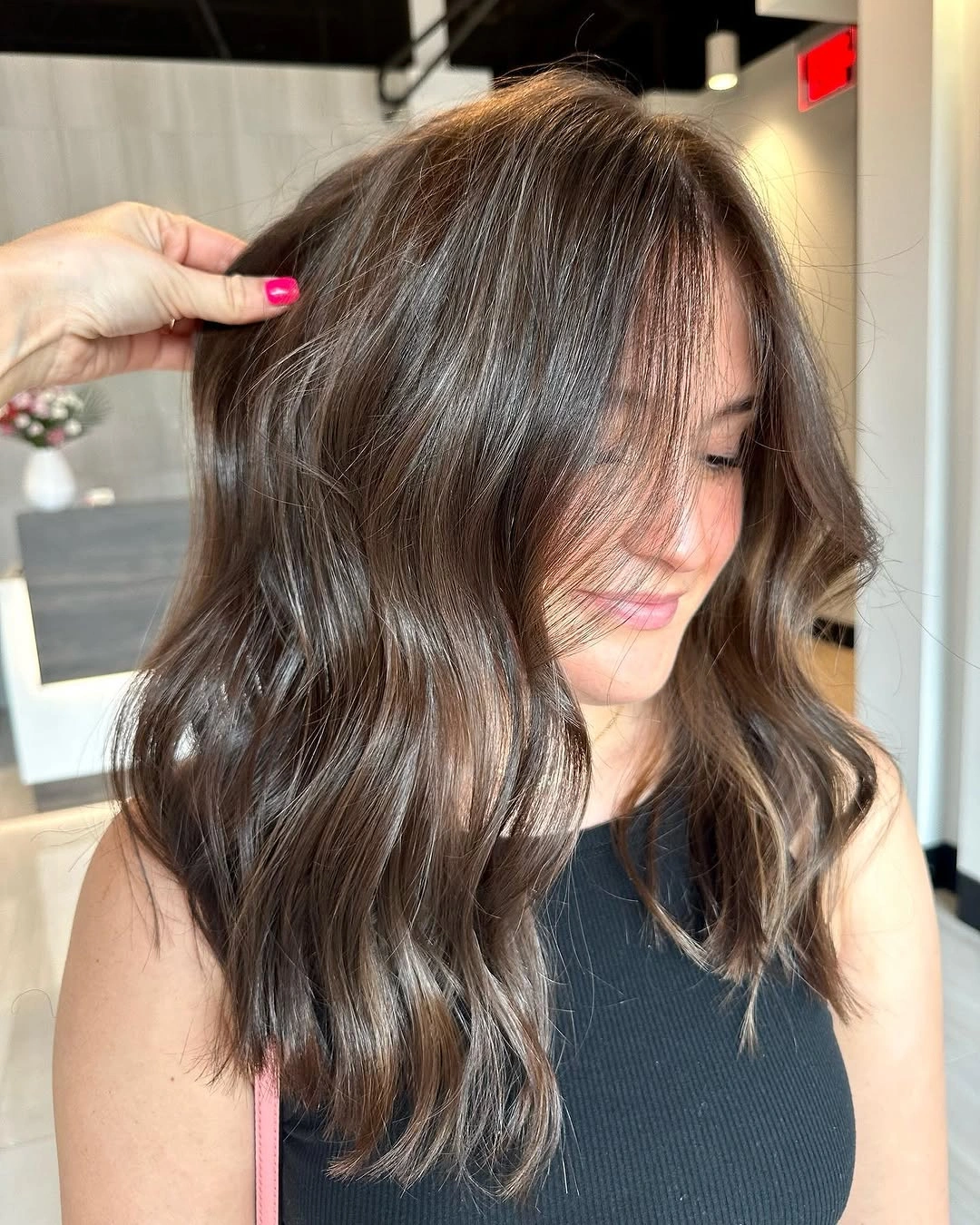 Medium chocolate-brown hair with broad waves and long face-framing sections