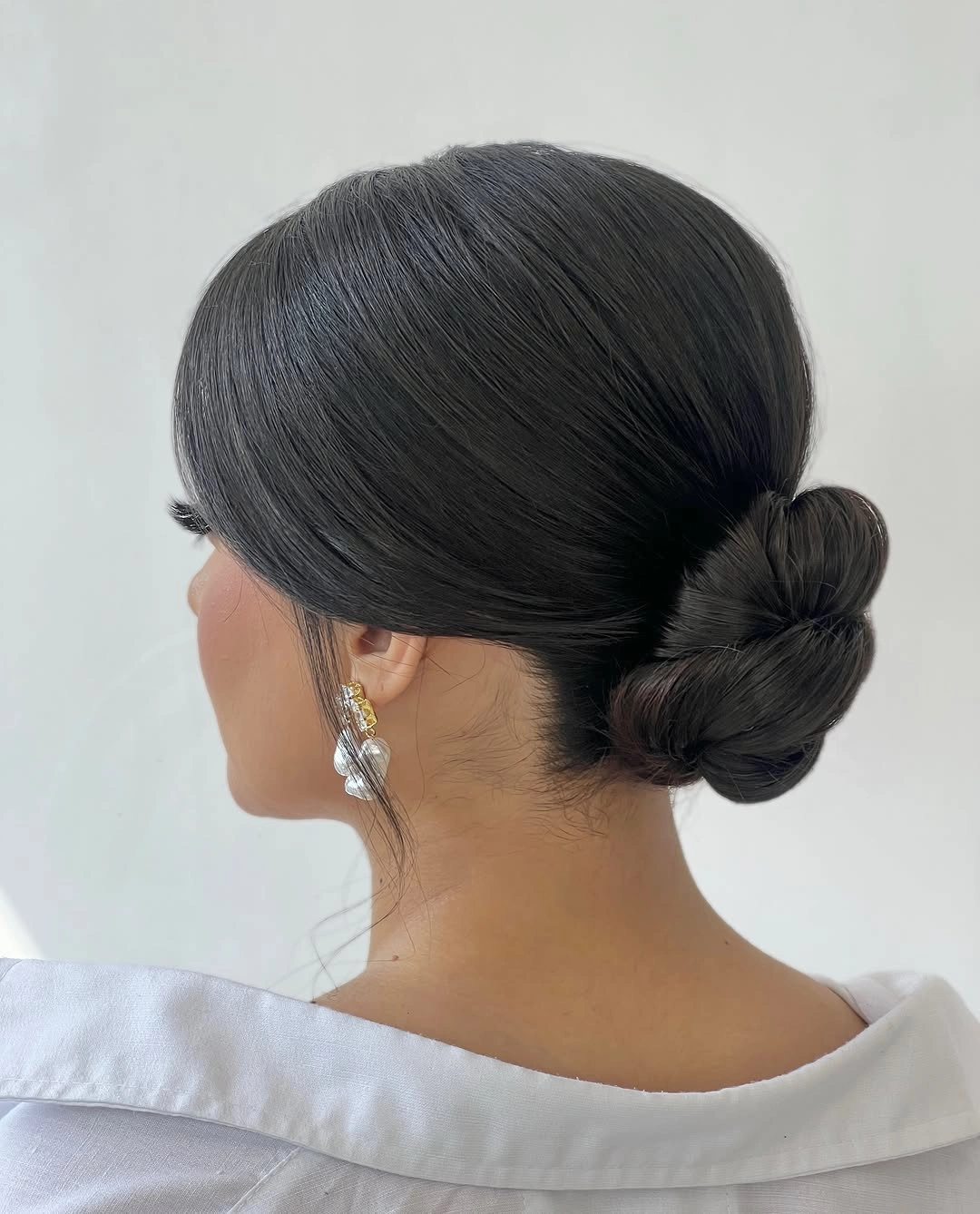 Dark hair in low bun with smooth side-swept top