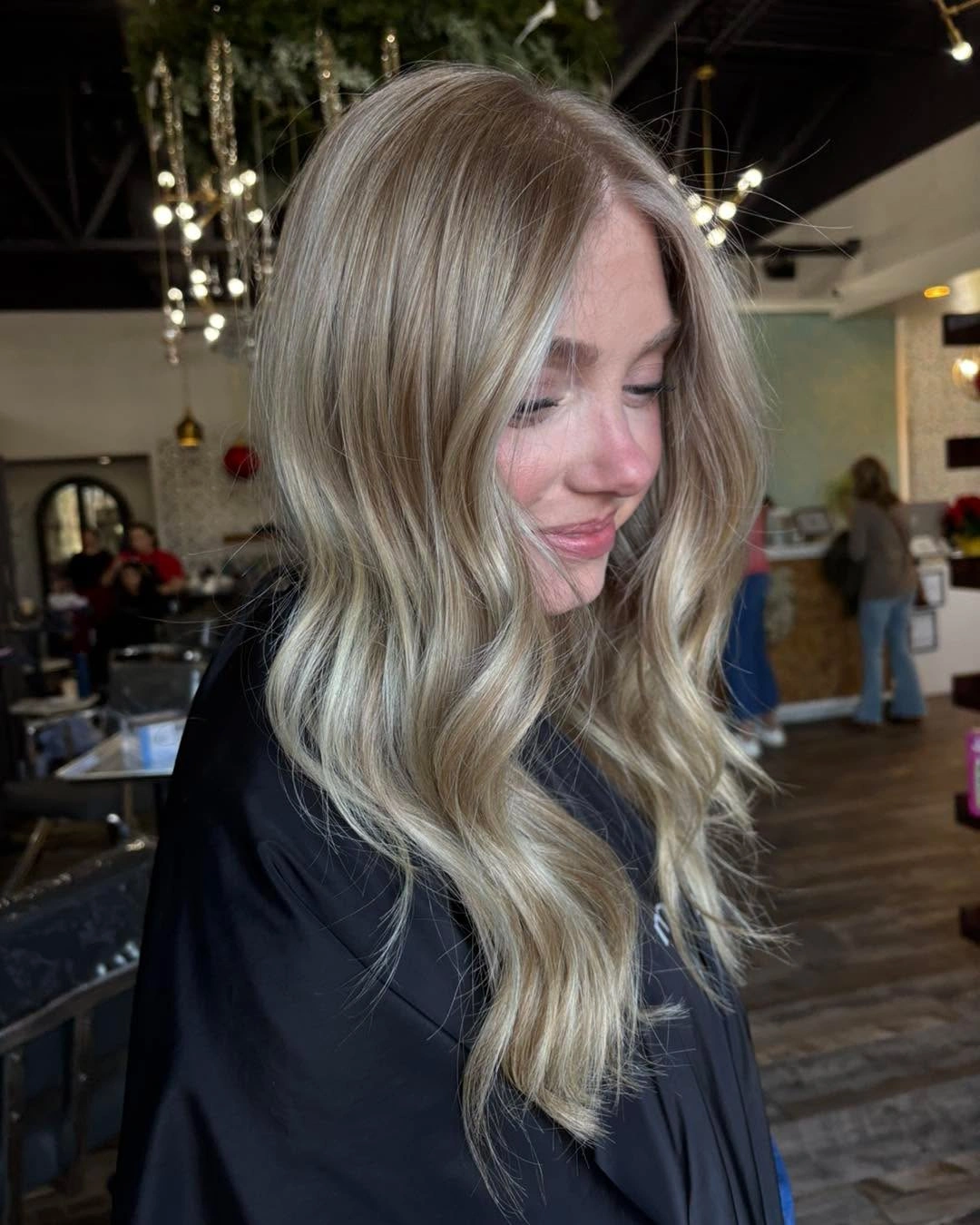 Long cool blonde hair with darker roots and soft waves