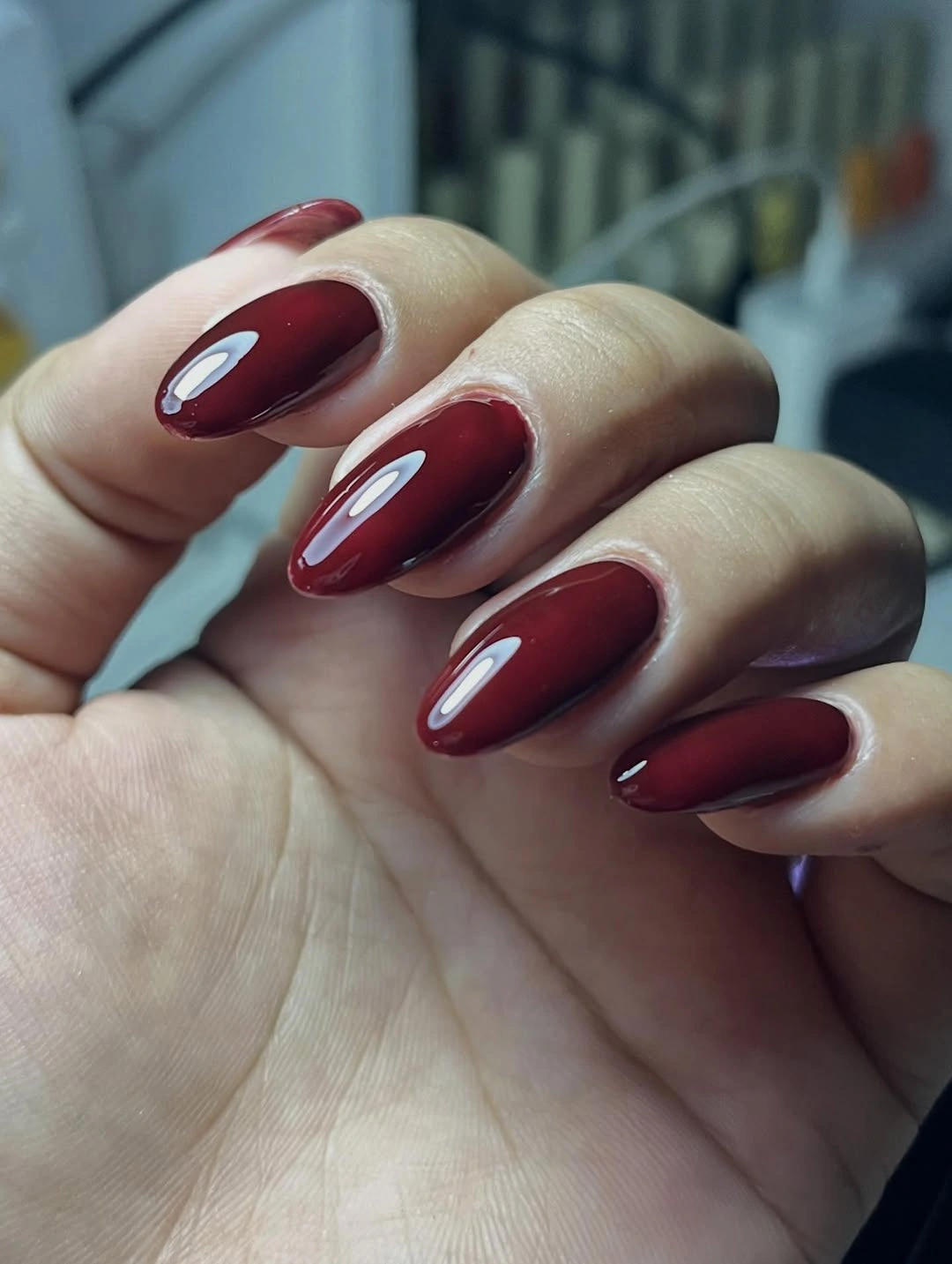 Almond nails in uniform glossy deep wine burgundy color
