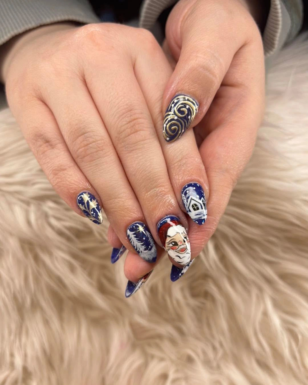 Almond nails in navy, white, gold, stars, and Santa detail