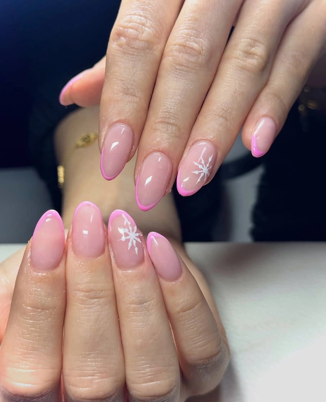 Pink jelly almond nails with bright French tips and white snowflakes