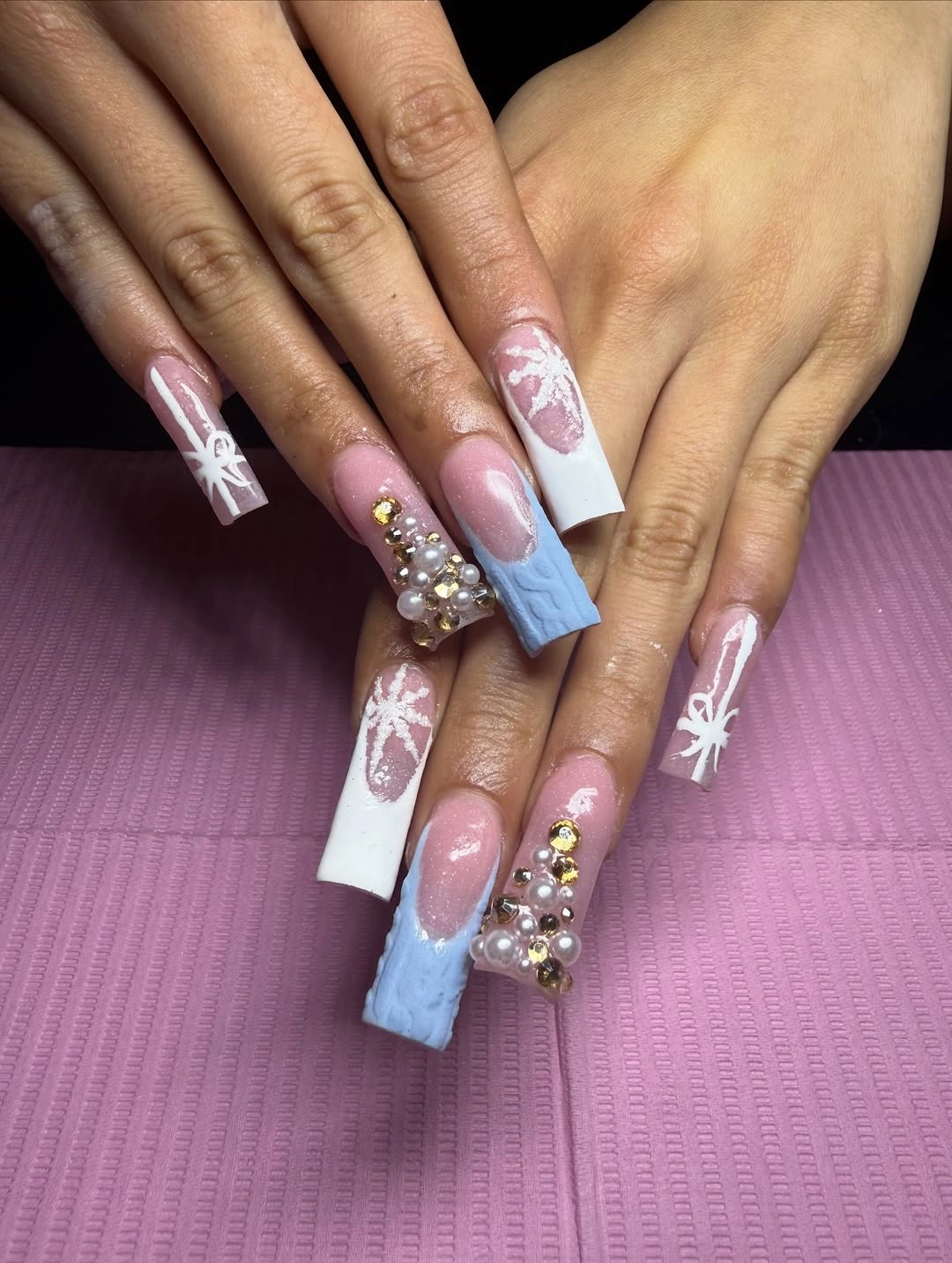 Long square nails with pink, blue, snowflakes, glitter, and pearl decoration