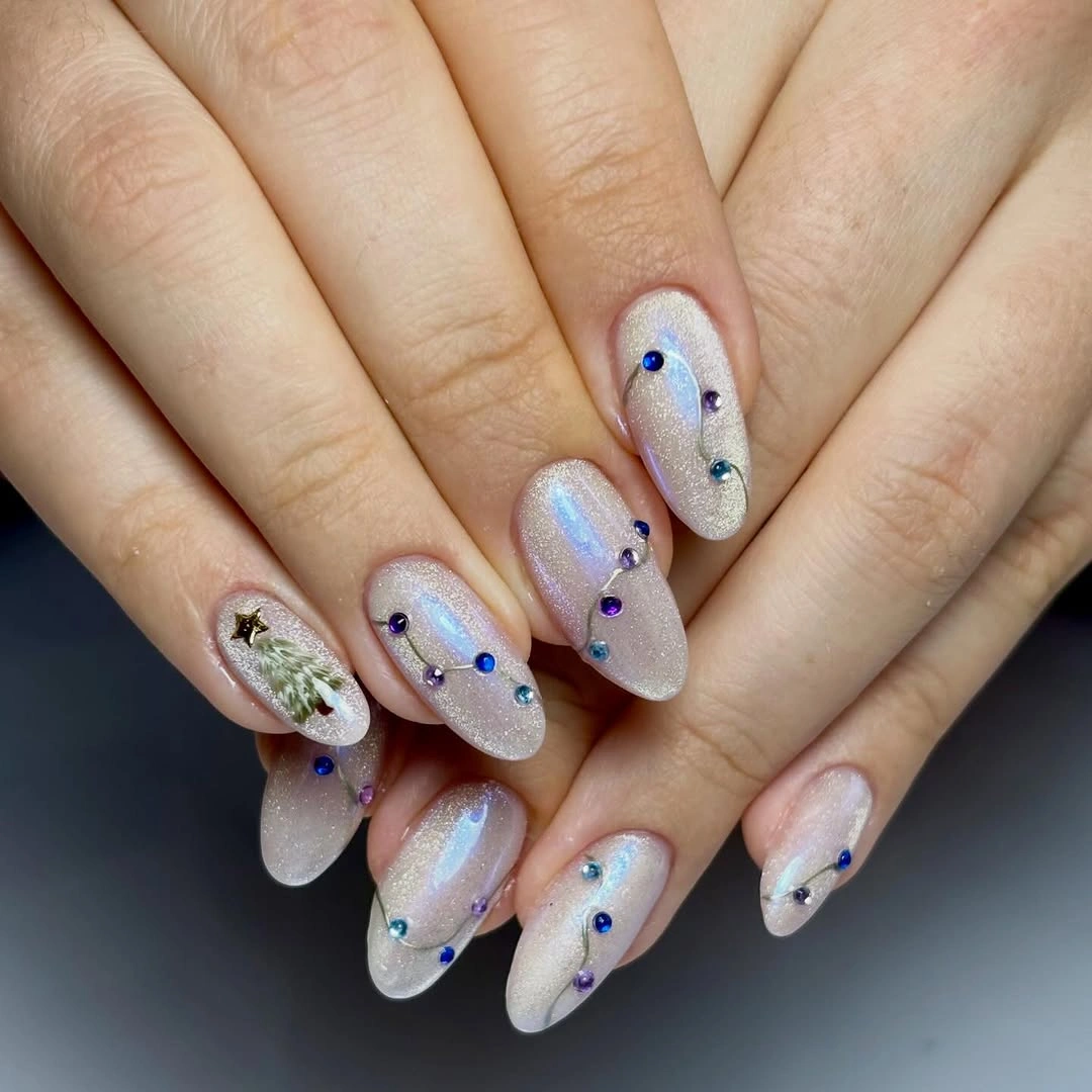 Pearly almond nails with blue purple jewels and green tree