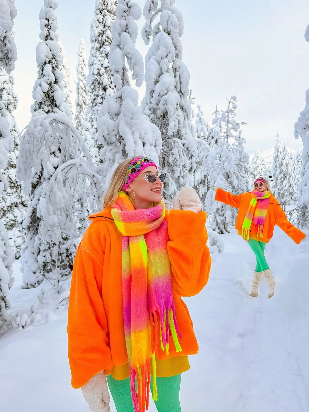 Orange outer layer, pink scarf and hat, green pants, gloves, and sunglasses in snow