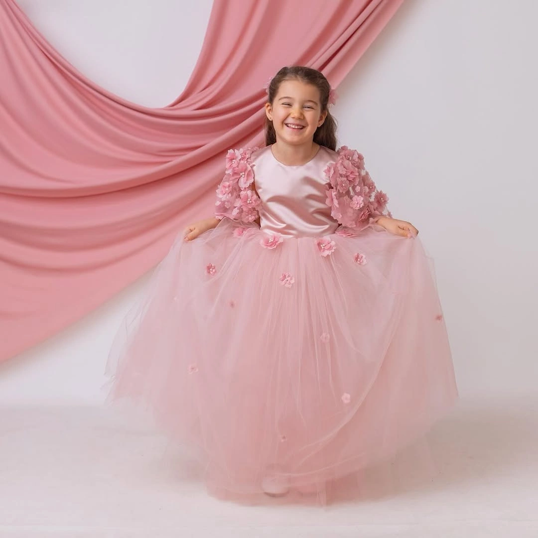 Child in blush pink full dress with floral sleeve details